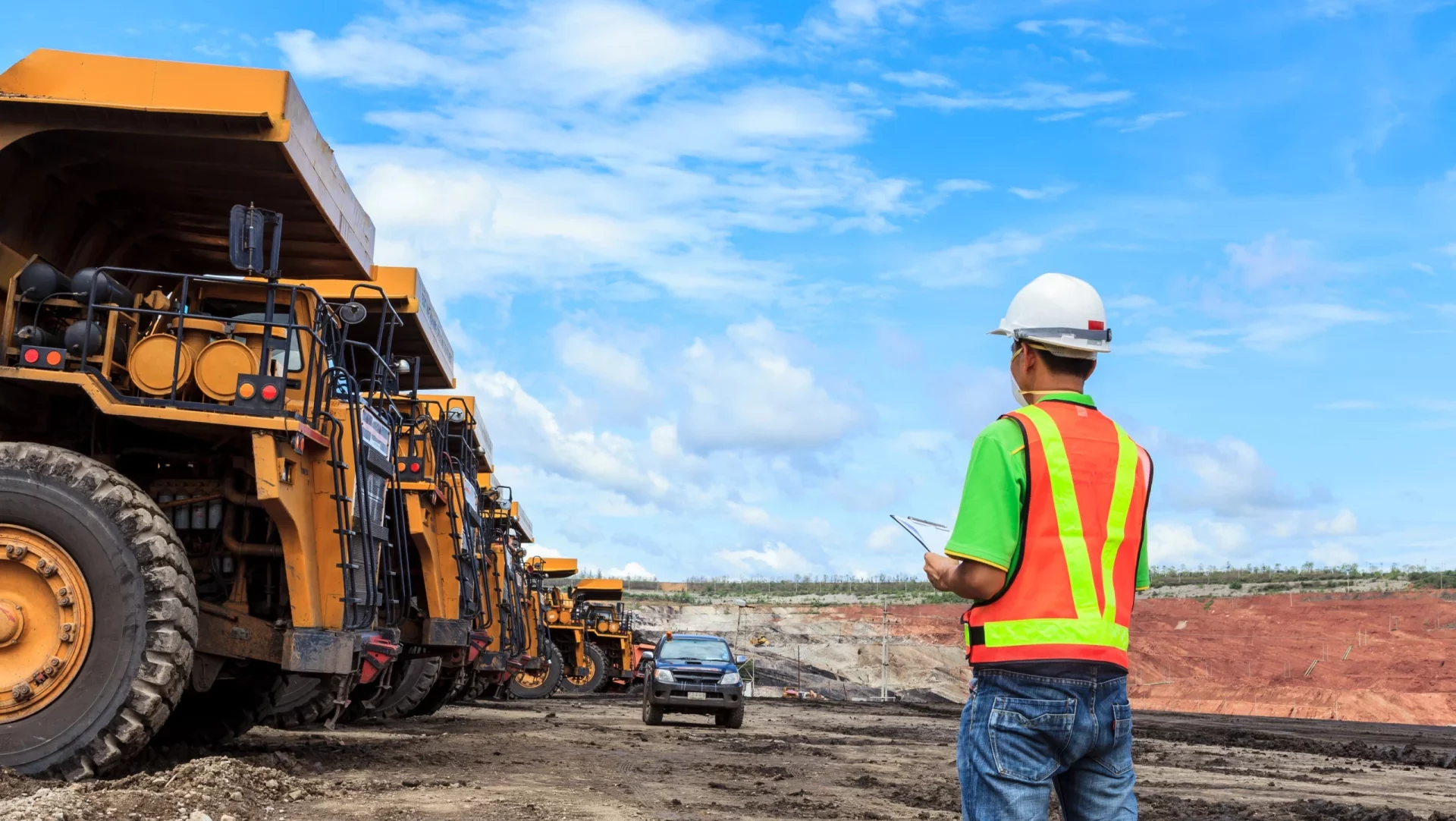 Construction worker supervising heavy machinery operations on an active worksite