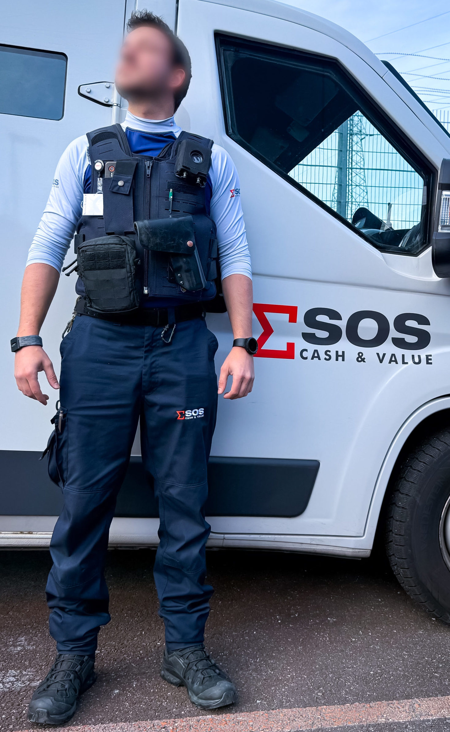 A SOS Cash&Value agent equipped with Wearin' safety solution in front of an armored van